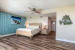 A colorfully decorated master bedroom with wood plank floors